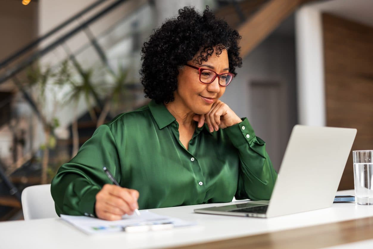 Woman smiling and working confidently at desk