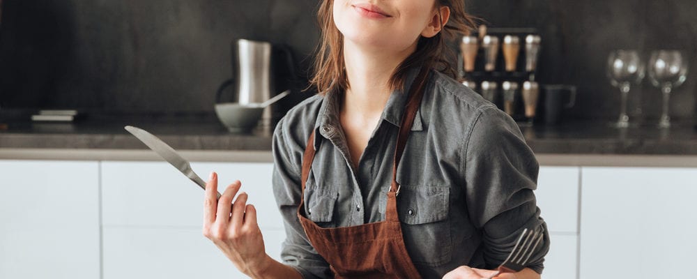 A woman slowly enjoying her meal and practicing mindful eating tips to take control of her hunger and appetite. Here are mindful eating tips to get you started!